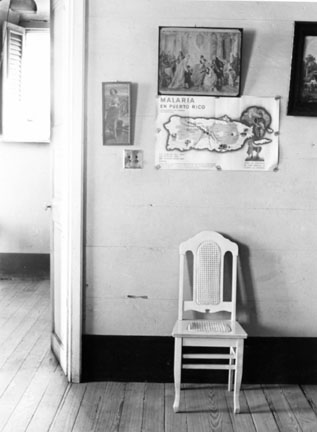 White Chair & Malaria Poster in Guesthouse, Manati