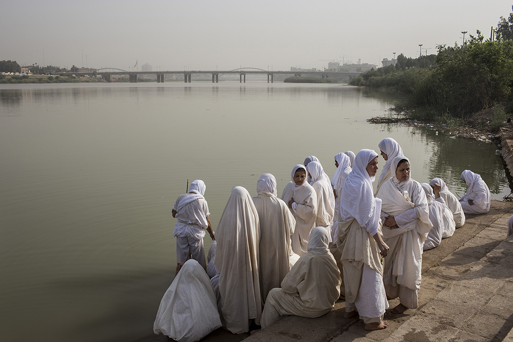 Ahvaz, Iran. Female members of the ancient Sabaean Mandean religious sect perform a ritual cleansing during an annual baptism held on the banks of the Karoun River. Water is everything to the Sabaean Mandeans who are baptized in it, get married in it, and receive their last rites by the river's edge.