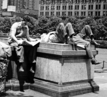 Untitled (man reading paper men laying on stone pedestal)