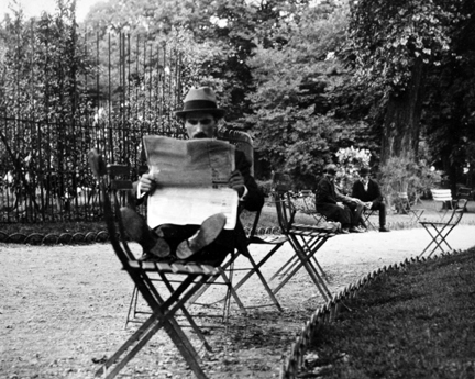 Jardin de Luxembourg (man reading newspaper with feet on chair)