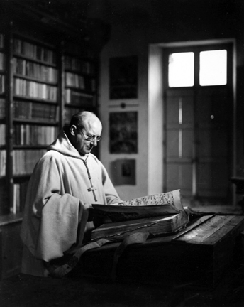 Trappist Cloister, Soligny sur Orne, France (priest reading a book of song)