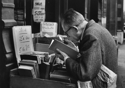 Fourth Avenue, New York (man with loop reading at book stand)
