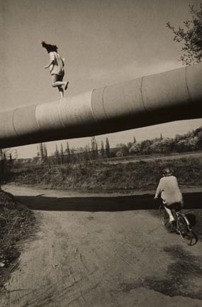 Untitled (Two youths: one walking on pipeline, one riding bike), from the 