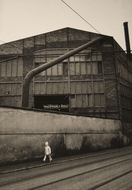 Untitled (child walking by factory wall), from the 