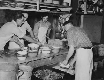 Dishing out and serving food in logging camp near Effie, Minnesota