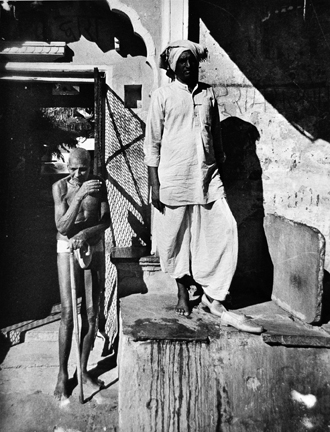 LL1018 (man standing on ledge with old man in loincloth, India)