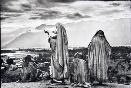 Srinagar, Kashmir, Muslim women on the slopes of Hari Parbal Hill, praying toward the sun rising behind the Himalayas, from the 