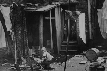 Negro backyard near Capitol, Washington, D.C. Negro children have just discovered the cameraman and are concerned at his presence