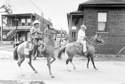 Two Men on Horses Go To Start of the Mexican Parade at the School Yard, September 1987