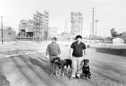 Two Men and Their Dogs on an Abandoned Steel Mill Parking Lot