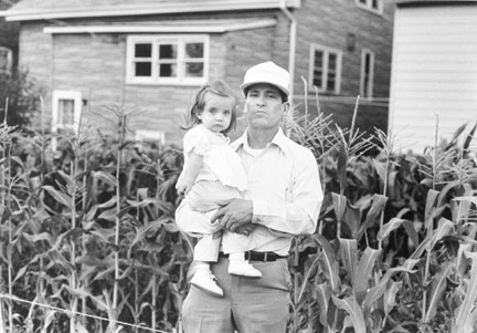 A Man and Child Near a Corn Shack Growing in a Neighbor's Backyard, July 1988